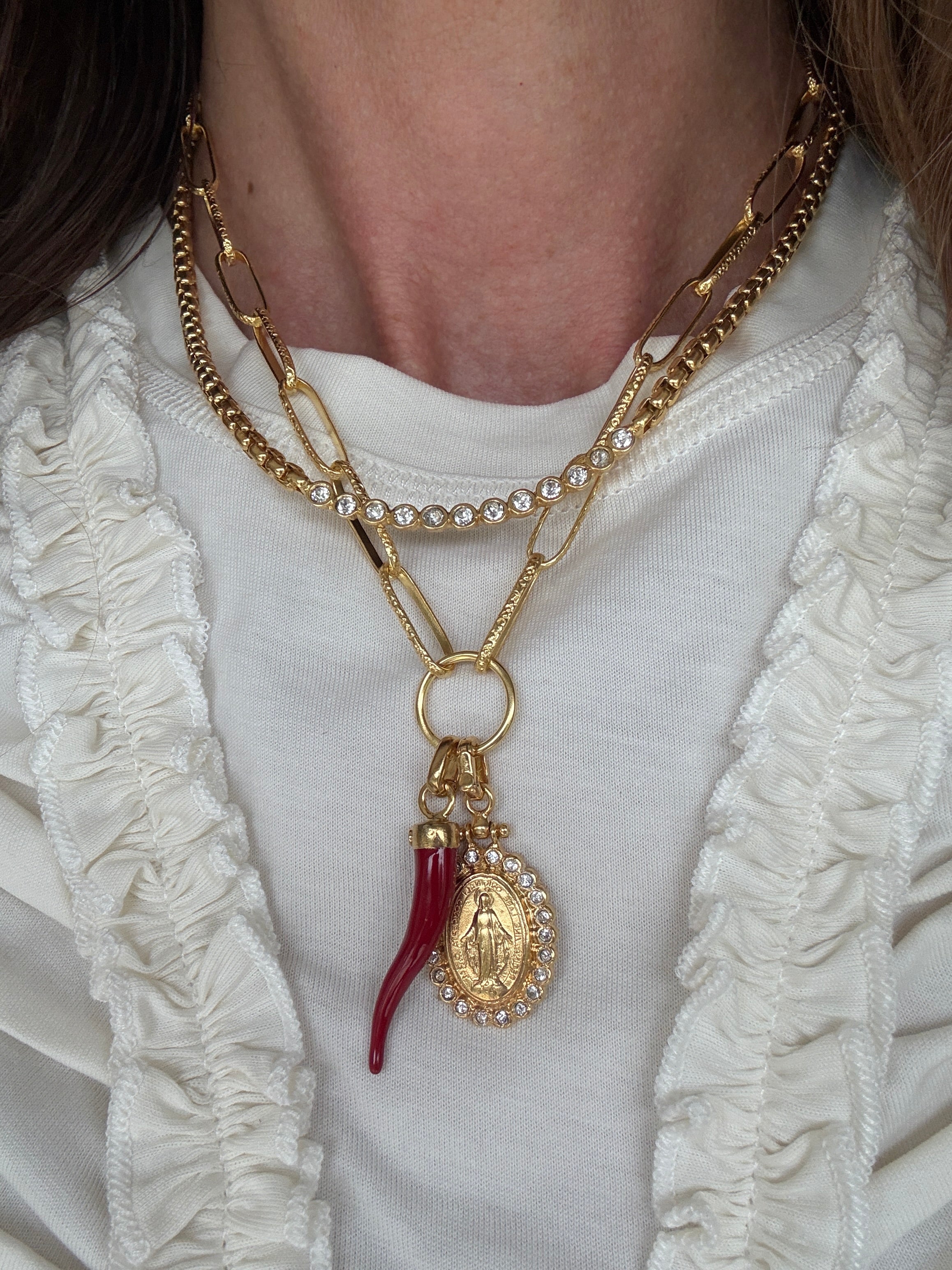 Image of soru charm chain with madonna pendant and red cornucopia pendant charm  and soru scomo necklace around a neck