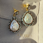 Pair of pearl earrings on a branded jewelry box