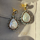 Pair of pearl earrings on a branded jewelry box