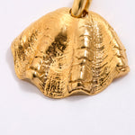 Gold coloured shell pendant with a textured surface on a white background