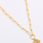 Gold necklace with a shell-shaped pendant on a white background