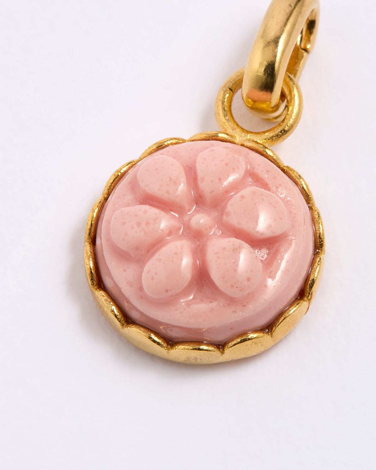 Pink floral pendant with gold frame on a white background