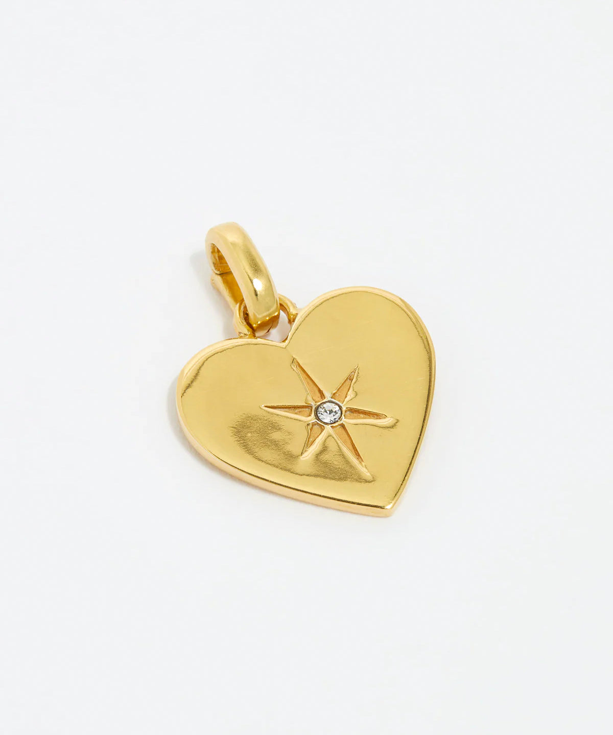 close up image shot clear crystal surrounded by a star etching set in a shiny gold heart.