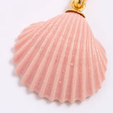 Pink shell pendant with gold accent on a white background