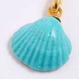 Turquoise shell pendant with gold chain on a white background