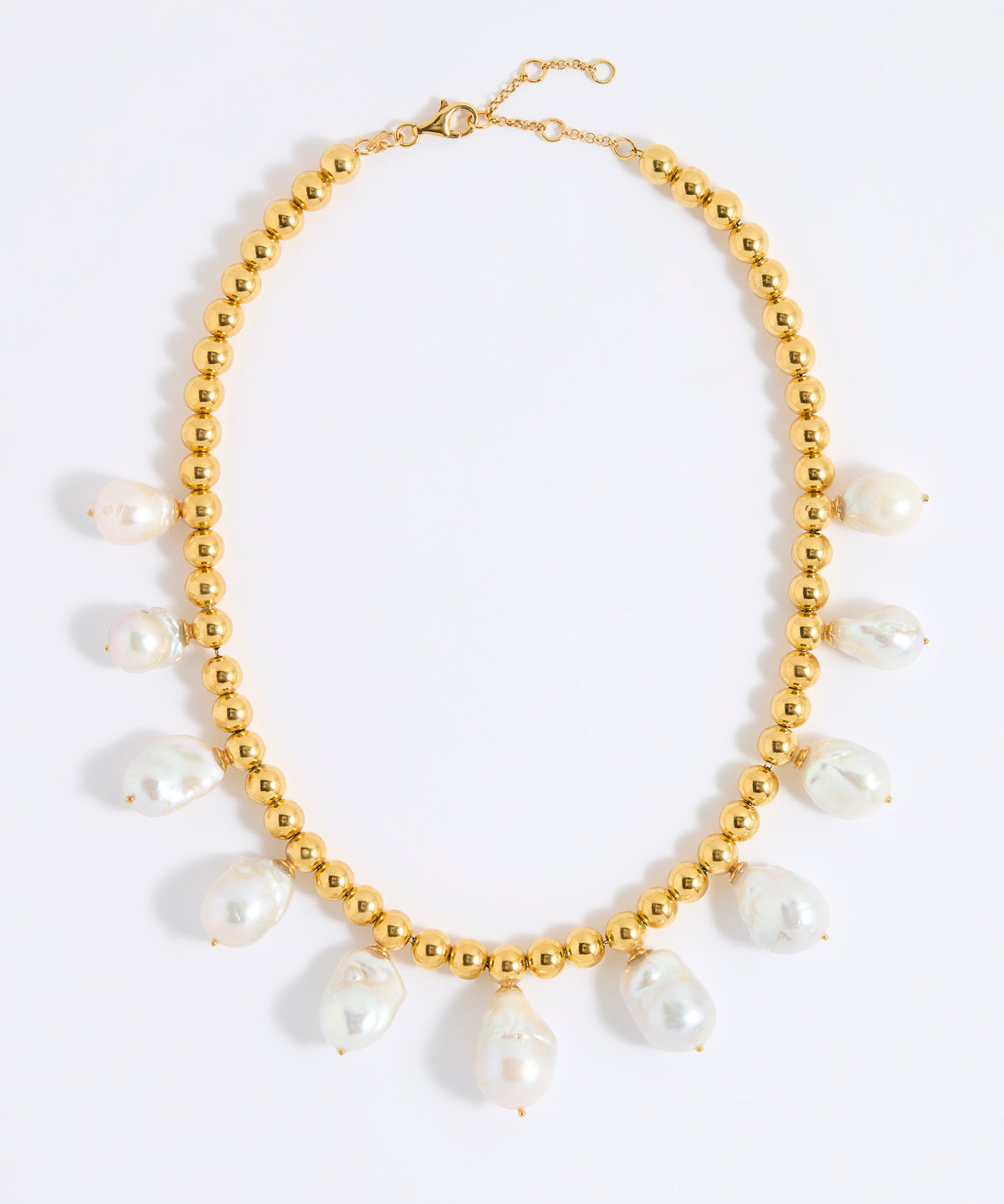 Gold necklace with white pearls on a white background