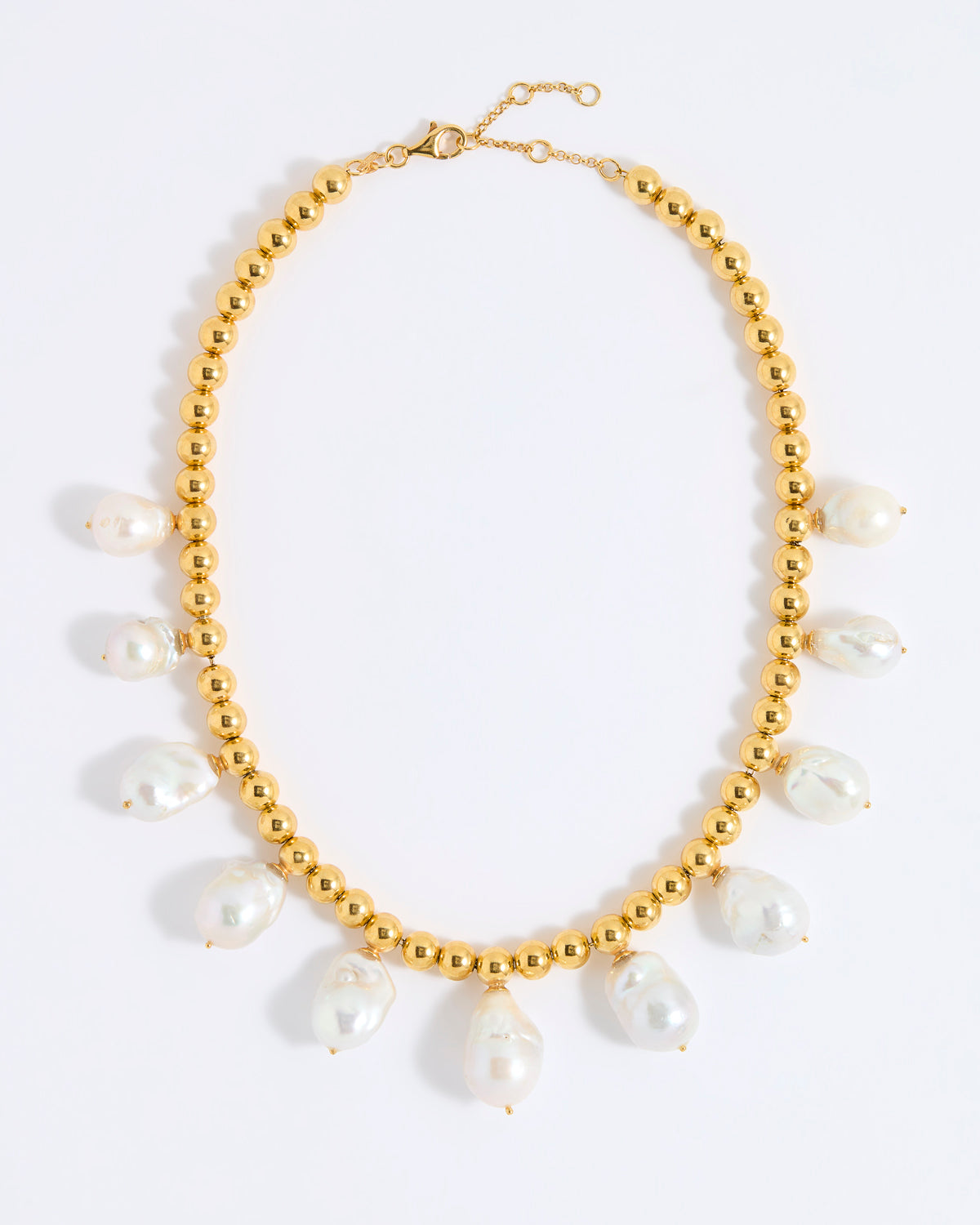 Gold necklace with white pearls on a white background