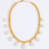 Gold necklace with white pearls on a white background