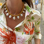 on model shot of gold beaded necklace with statement white pearls being worn.