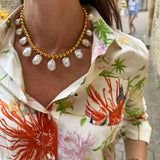 on model shot of gold beaded necklace with statement white pearls being worn.