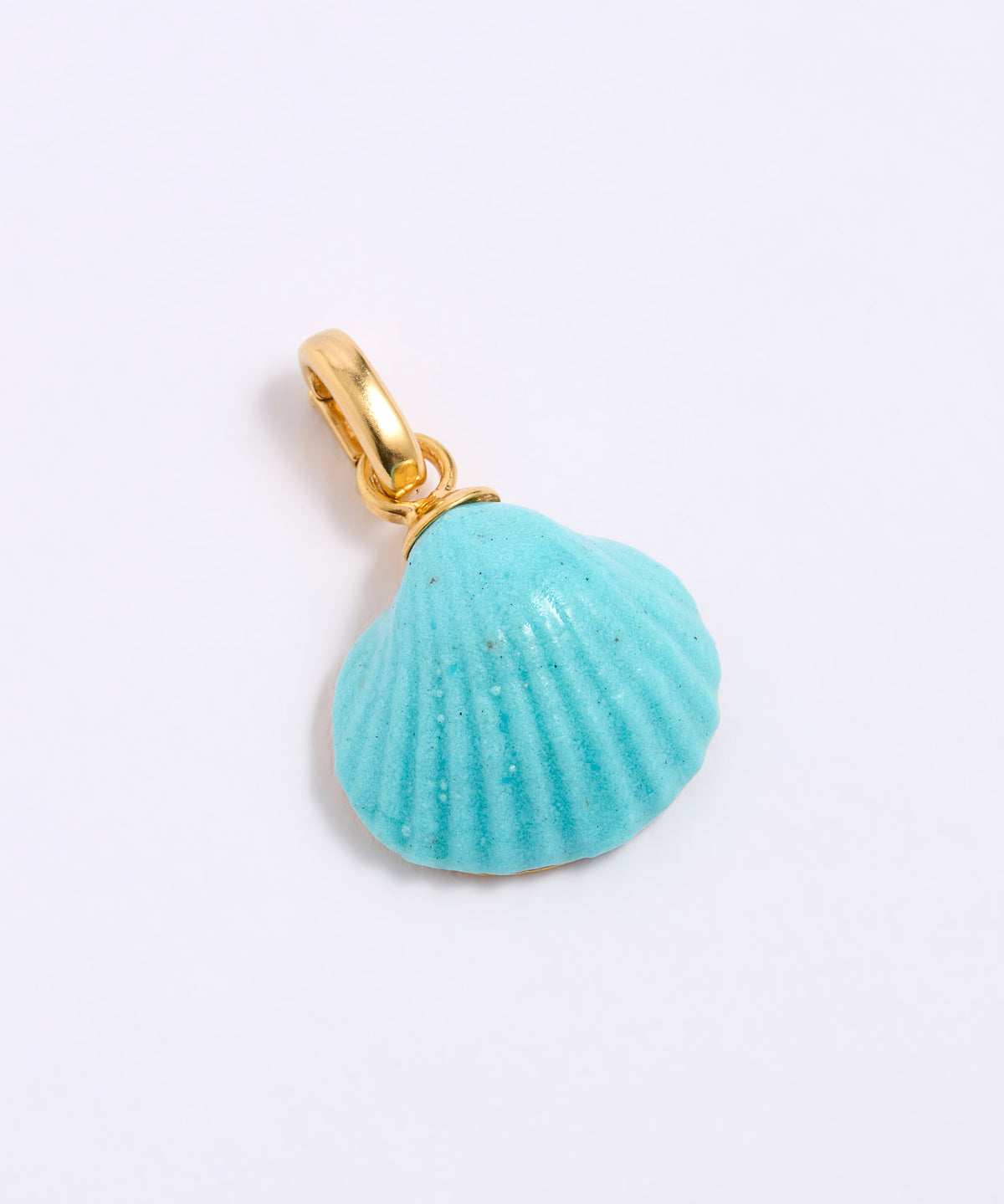 Turquoise shell pendant with gold coloured clasp on a light gray background