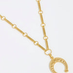 product shot of gold bar lingunine chain with horseshot charm