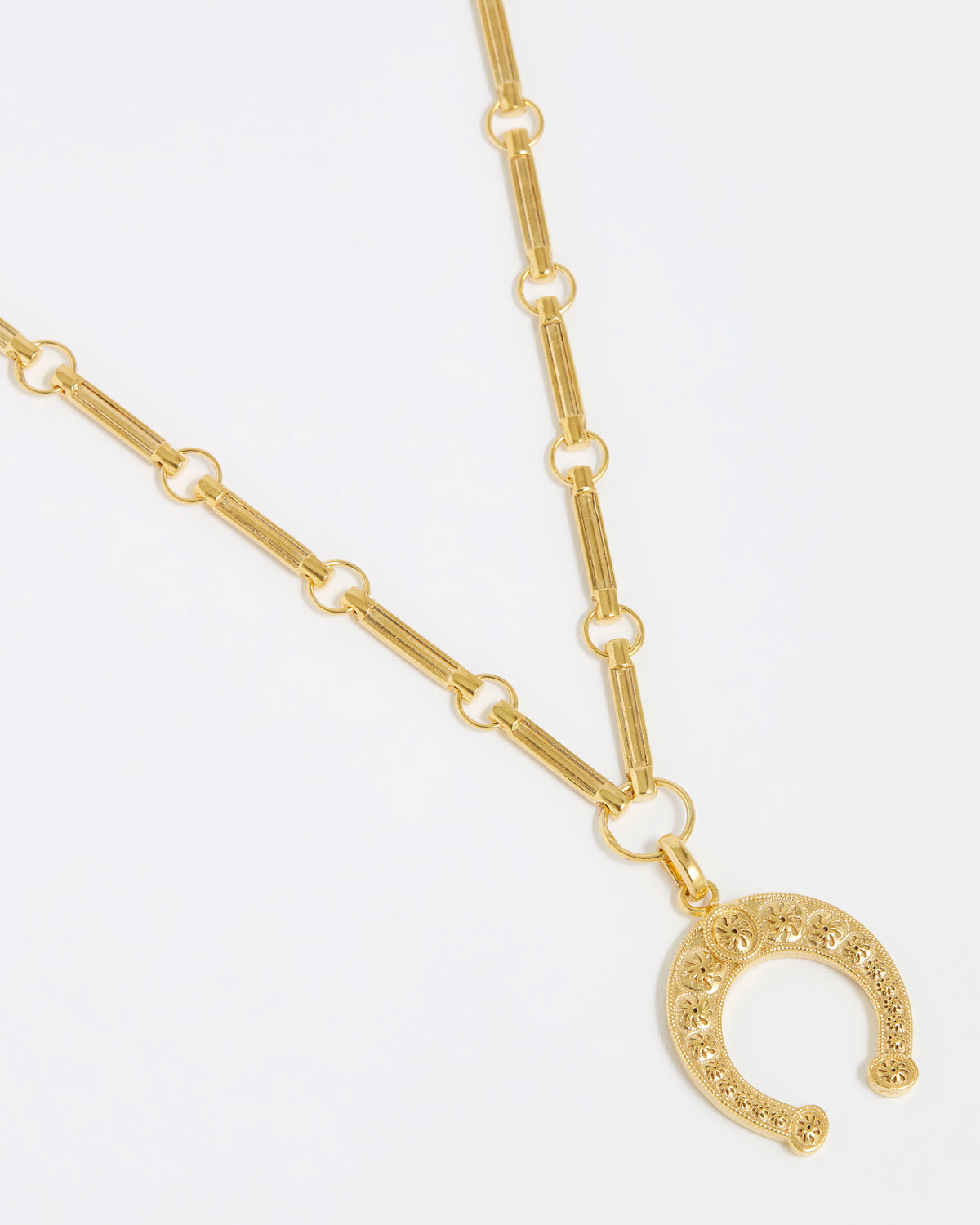product shot of gold bar lingunine chain with horseshot charm