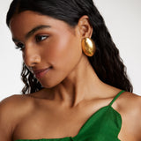 side view model shot wearing the Soru Jewellery gold oversized textured oval earrings while model is smiling