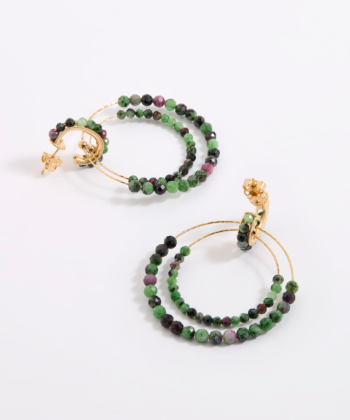 A pair of delicate gold double-hoop earrings, adorned with multiple strands of small, faceted beads in rich shades of green, dark charcoal, and purple, displayed against a white background.