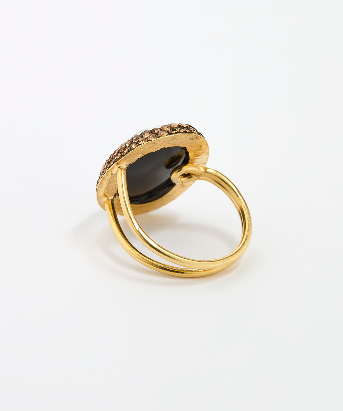 Reverse image of a  gold ring with a large oval dark mood stone centre stone and a halo of small gold stones, photographed on a clean white background.