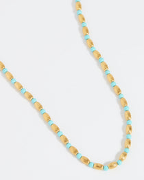 Product shot of gold plated silver and turquoise beaded necklace with toggle clasp on a white background.