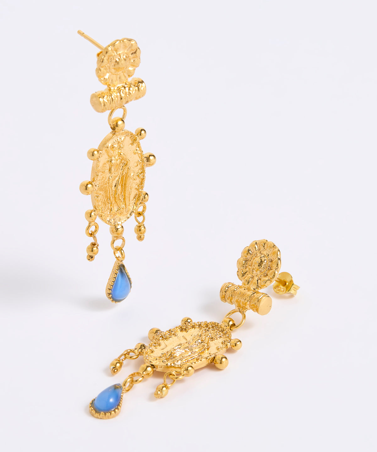 A pair of gold-toned statement dangle earrings with textured baroque-style charms and light blue teardrop accents, displayed on a white background.