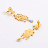 Reverse and front image of a pair of earrings, feature Oval, organically finished medallion featuring the figure of a woman. Handmade with classic detailing and a decorative border, finished with a delicate pale blue hanging glass cabochon.