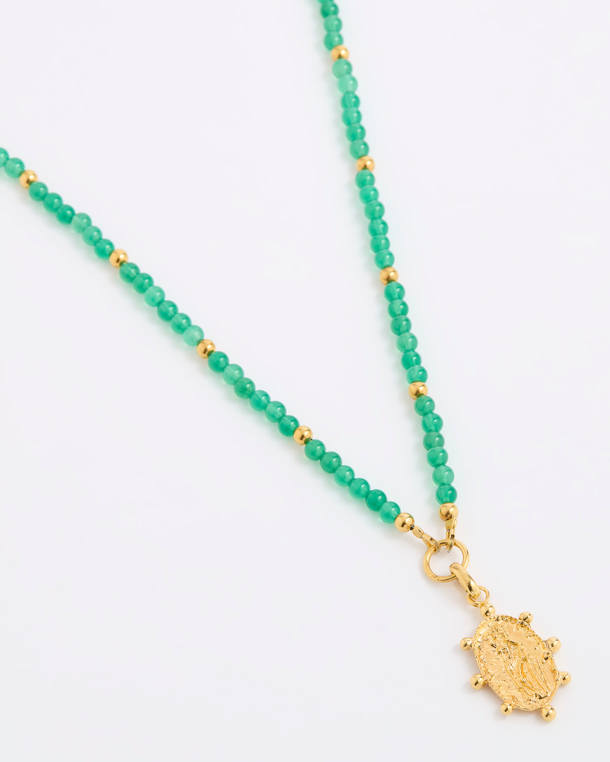A green beaded necklace featuring small green gemstone beads separated by tiny gold spacer beads, with a textured gold pendant at the end, displayed on a white background.