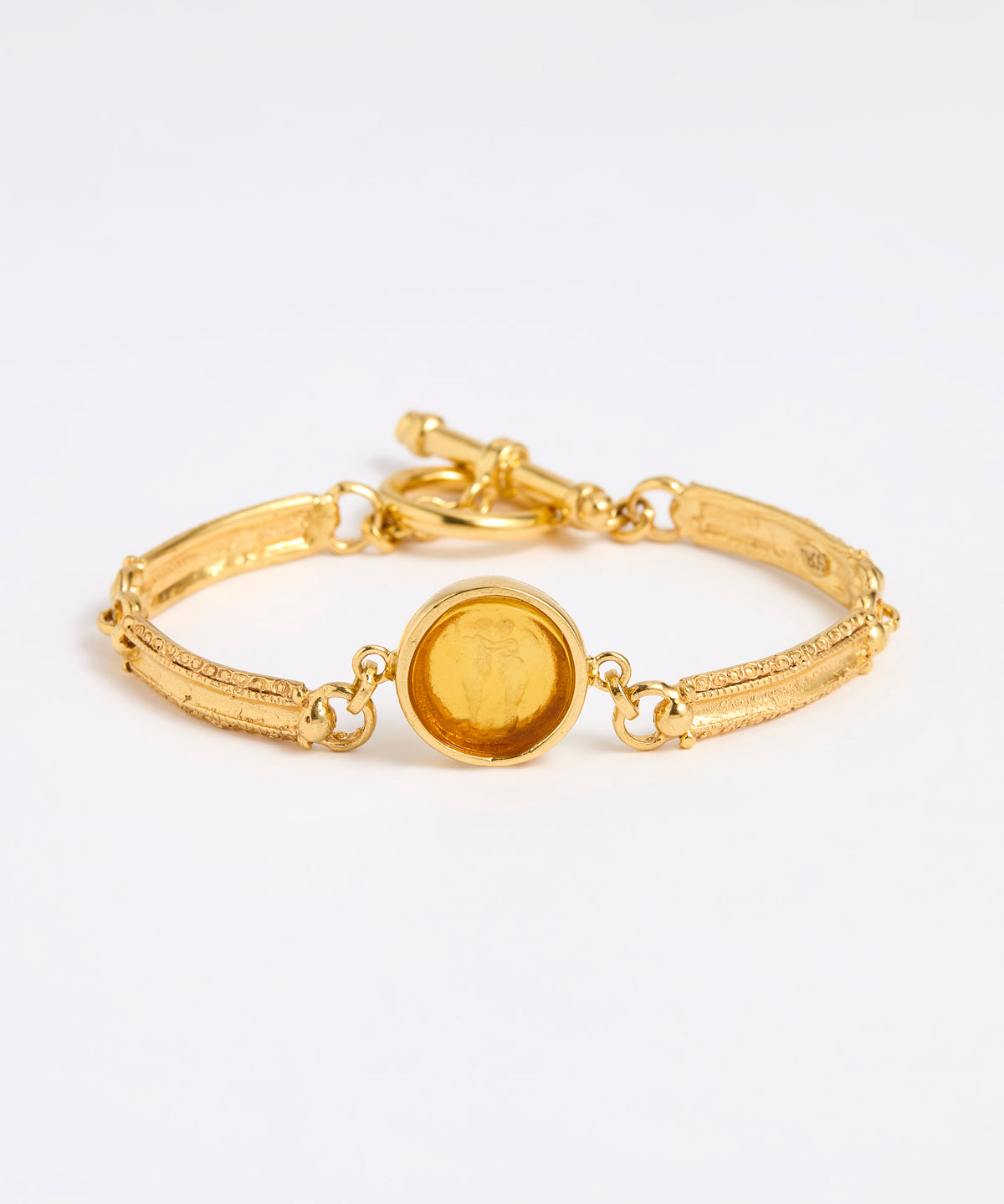 Gold link bracelet with round pendant in the centre with amber  glass