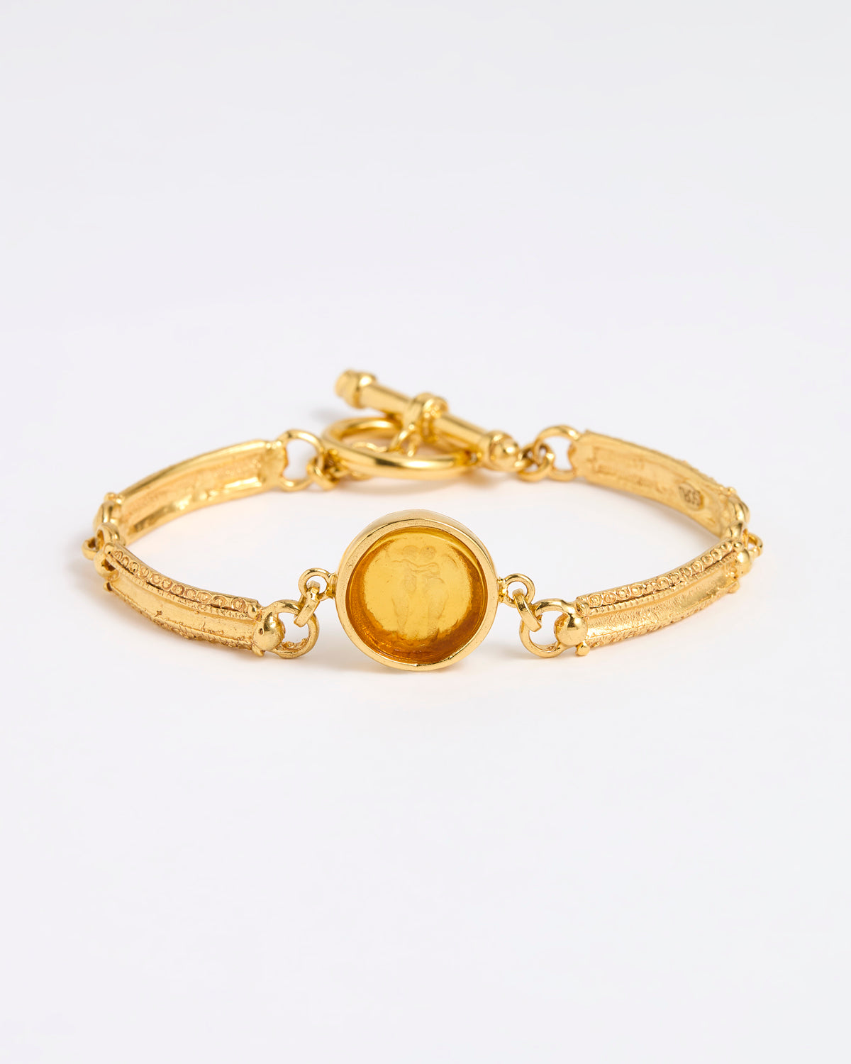 Gold link bracelet with round pendant in the centre with amber  glass