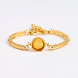 Gold link bracelet with round pendant in the centre with amber  glass