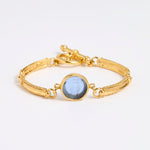 Gold link bracelet with round pendant in the centre with blue glass 