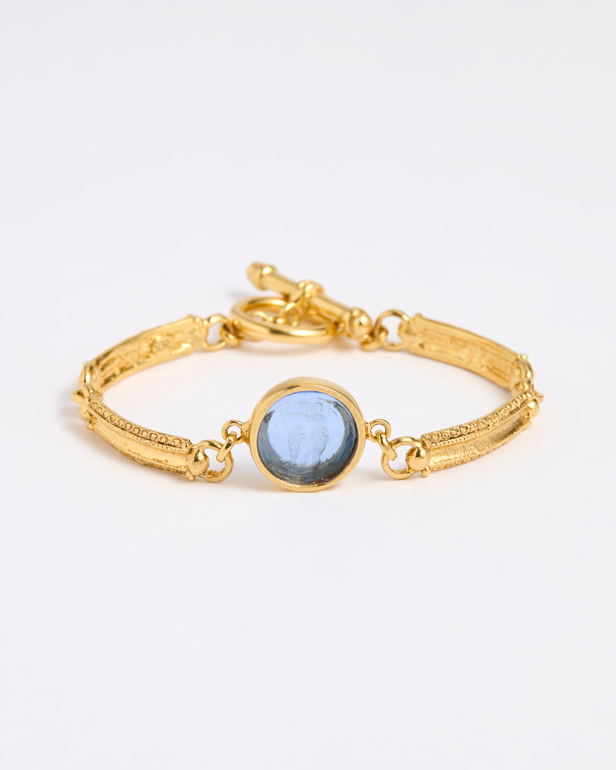 Gold link bracelet with round pendant in the centre with blue glass 
