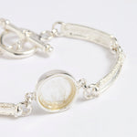 Silver link bracelet with round pendant in the centre with clear glass and embossed image of twins and inscription 'you are loved'