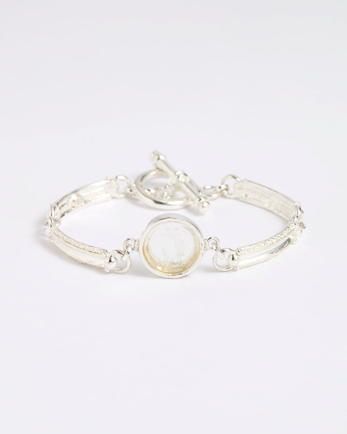 Silver link bracelet with round pendant in the centre with clear glass and embossed image of twins.