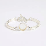 Silver link bracelet with round pendant in the centre with clear glass and embossed image of twins.