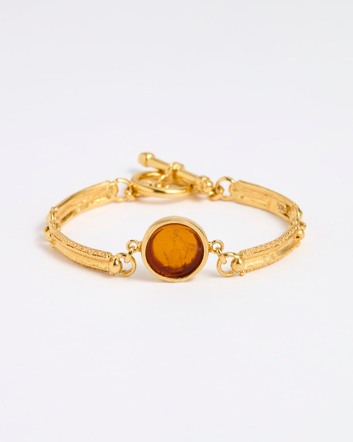 Gold link bracelet with round pendant in the centre with topaz glass