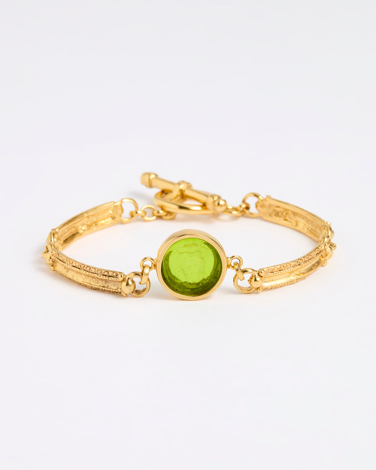 Gold link bracelet with round pendant in the centre with green glass 
