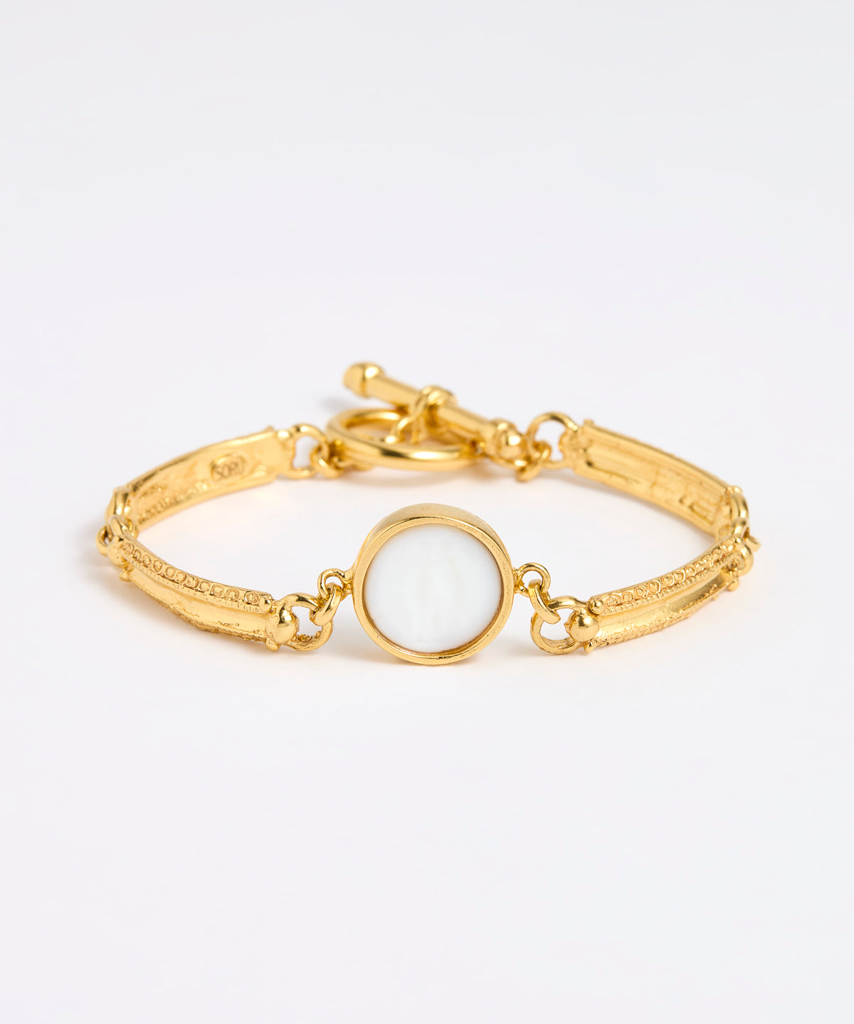 Gold link bracelet with round pendant in the centre with white glass