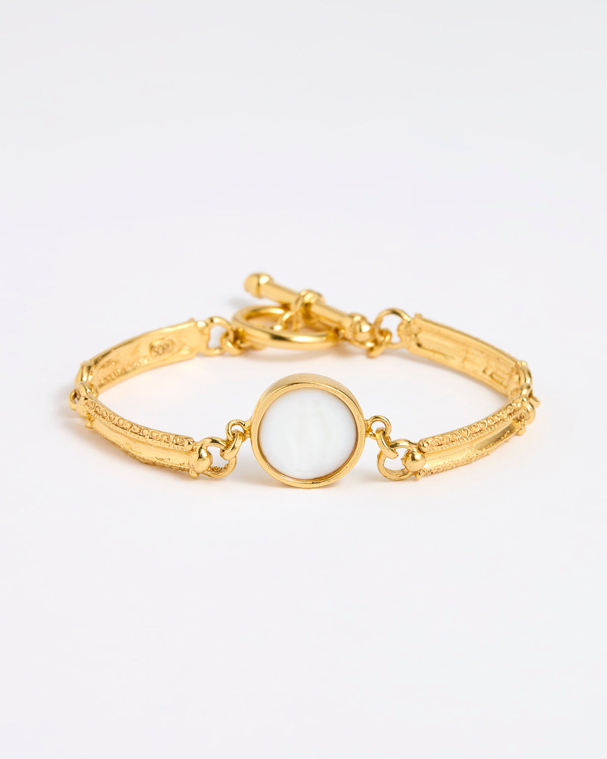 Gold link bracelet with round pendant in the centre with white glass