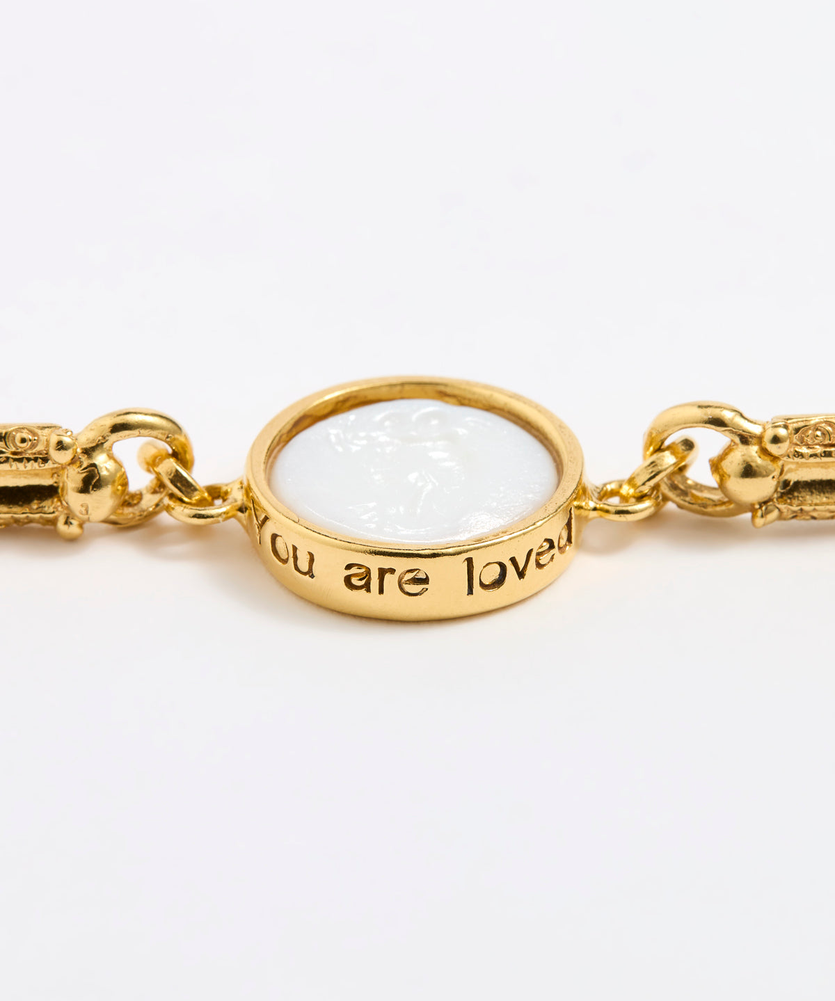 Gold link bracelet with round pendant in the centre with white glass and inscription 'you are loved' 
