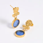Gold coloured earrings with blue glass centre