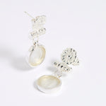 Silver drop earrings with round clear glass pendant featuring an image of twins.