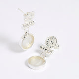 Silver drop earrings with round clear glass pendant featuring an image of twins.
