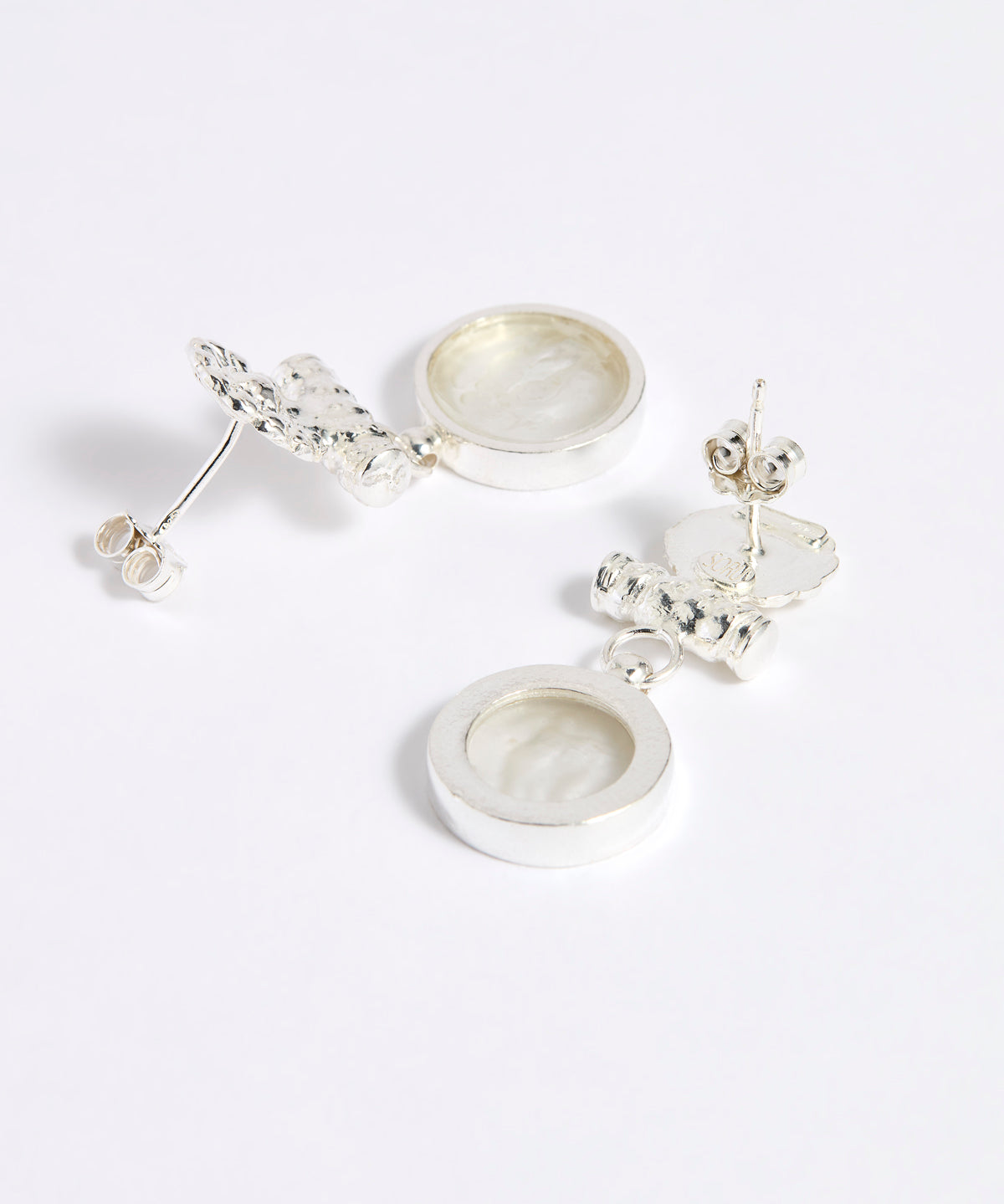 Reverse image of Silver drop earrings with round clear glass pendant featuring an image of twins.