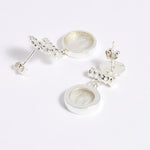 Reverse image of Silver drop earrings with round clear glass pendant featuring an image of twins.