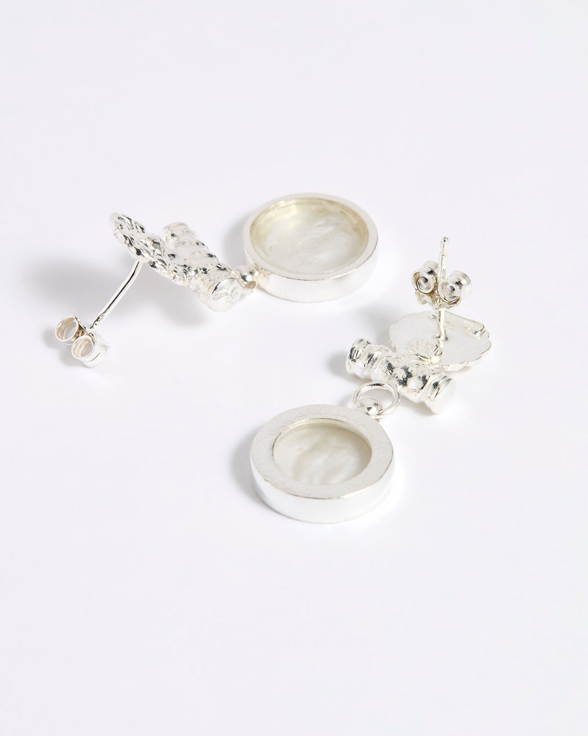 Reverse image of Silver drop earrings with round clear glass pendant featuring an image of twins.