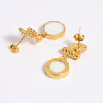 Reverse image of gold plated  drop earrings with round white glass pendant featuring an image of twins.