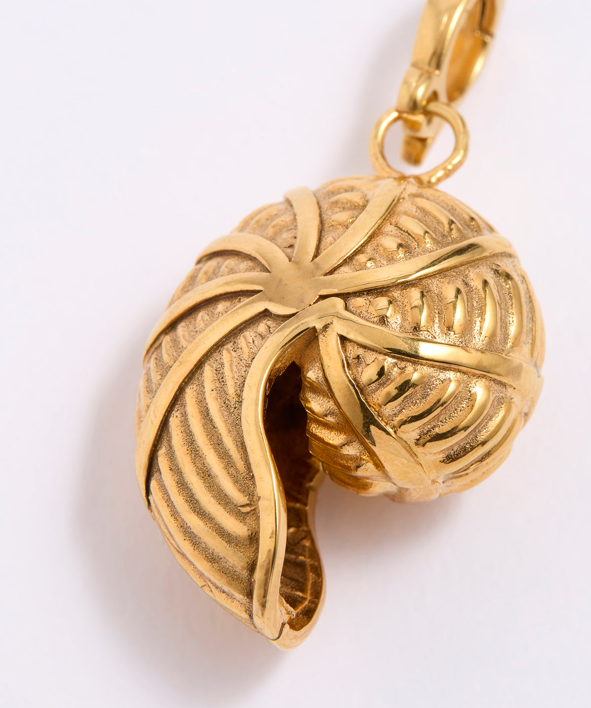 Gold SHELL SHAPED pendant with intricate design on a white background