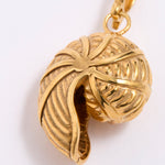 Gold SHELL SHAPED pendant with intricate design on a white background