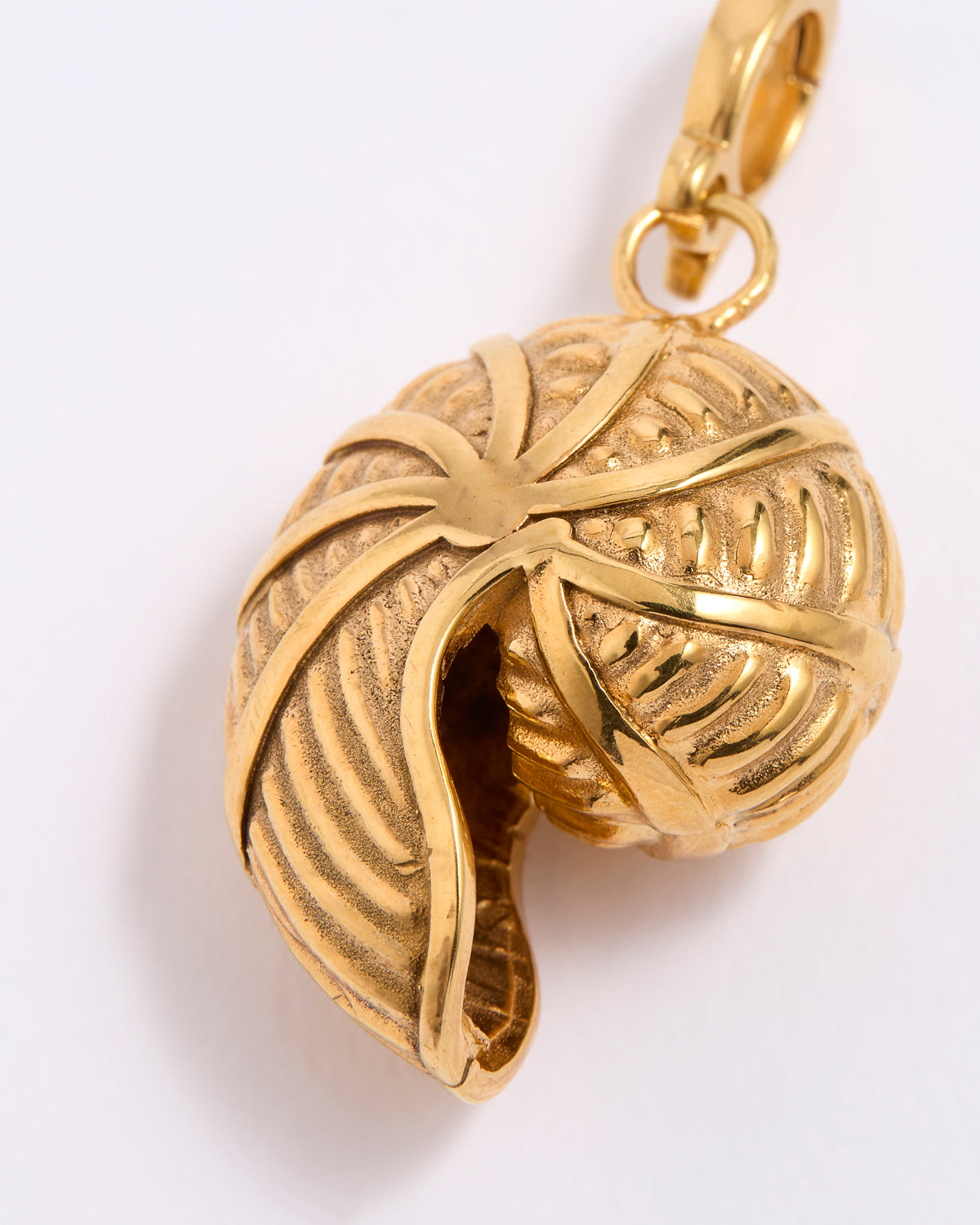 Gold SHELL SHAPED pendant with intricate design on a white background