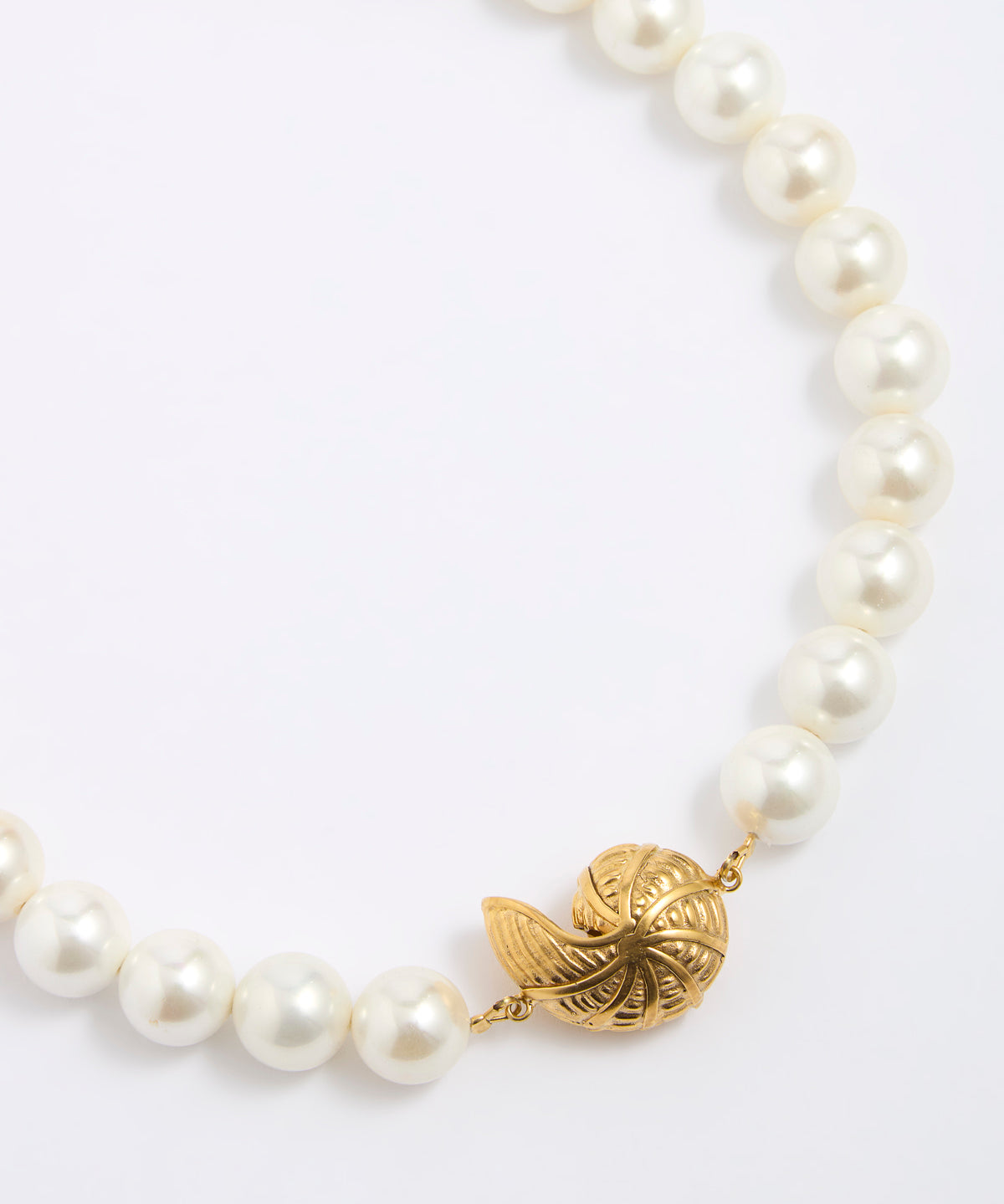 Pearl necklace with a gold coloured shell shaped pendant on a white background
