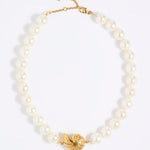 Pearl necklace with statement shell pendant  on a white background