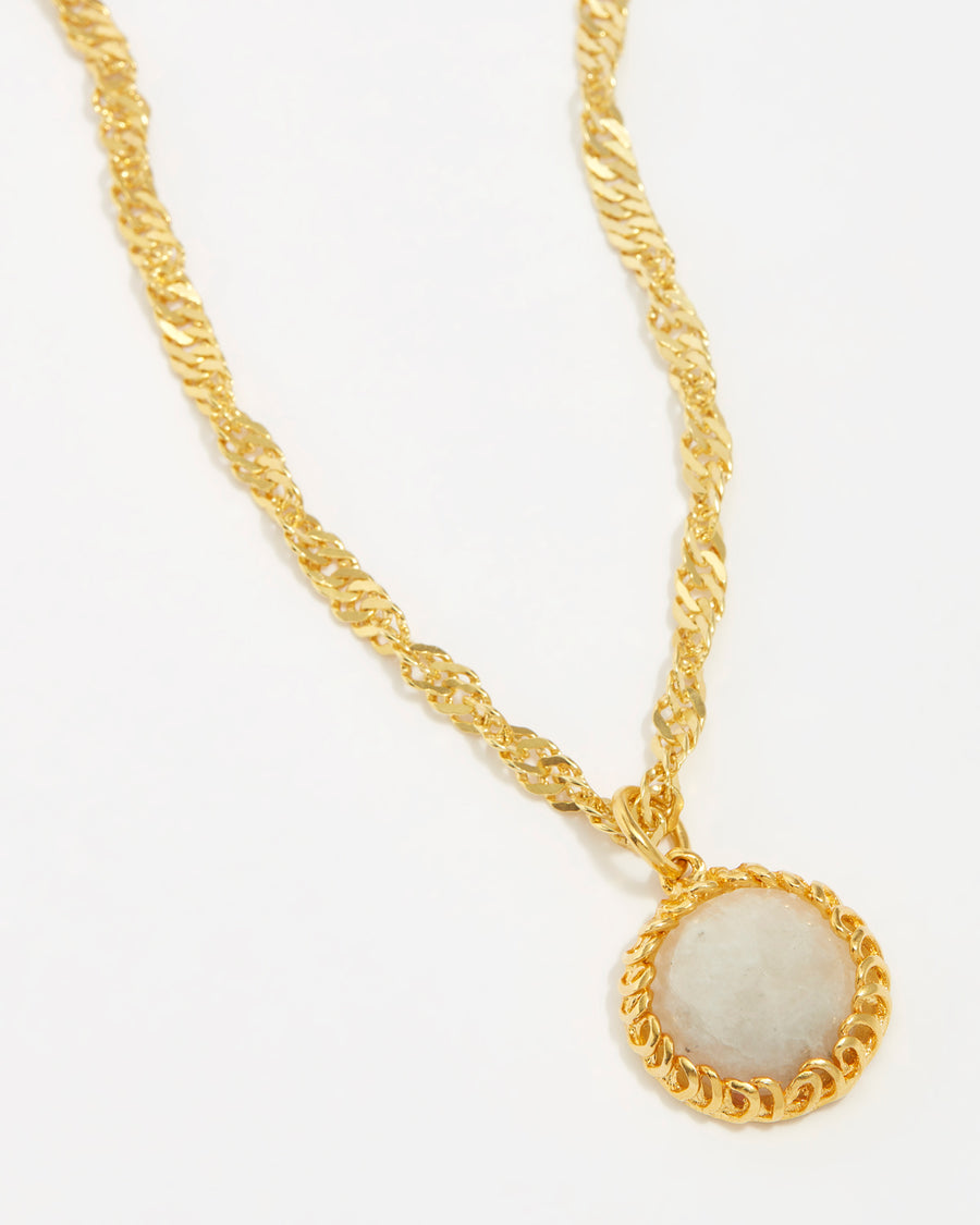 product shot of circular moonstone set in yellow gold plated pendant on a chain